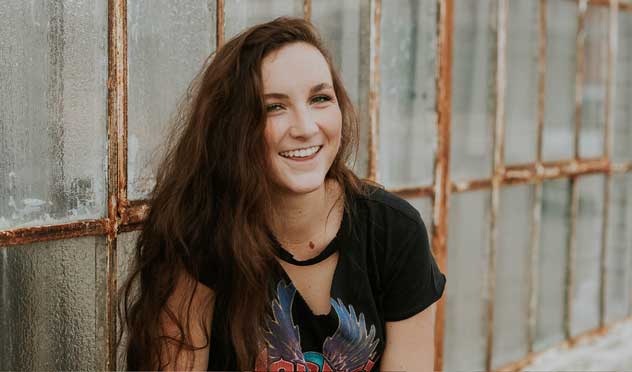 Woman in front of wall smiling